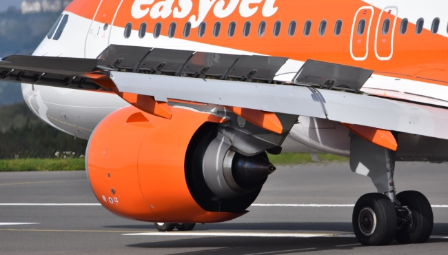 A view of an orange jet engine fitted to an EasyJet Airbus A320neo aircraft
