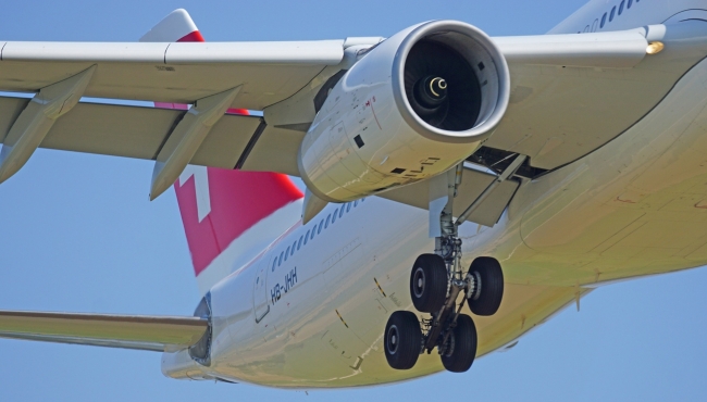 A jet engine mounted on the wing of an Airbus A330 aircraft on takeoff, with flaps and landing gear down
